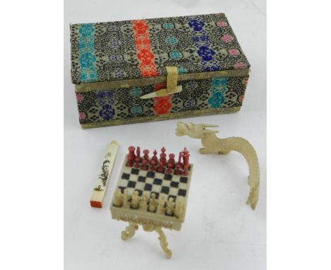 A 19th century miniature ivory chess table, with chess pieces, H: 4cm, together with a Chinese ivory seal decorated with figu