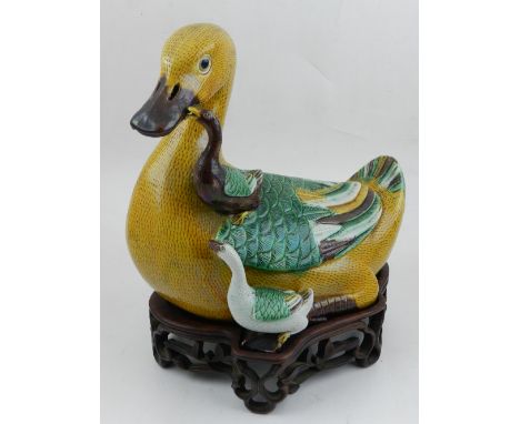 A late 19th / early 20th century Chinese ceramic figural study of a duck and ducklings, together with original hardwood base.