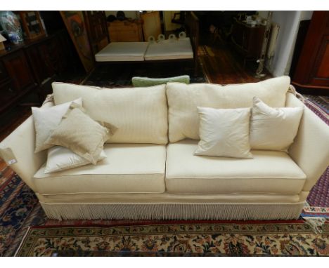 A contemporary Knoll-style drop-end two-seater sofa, upholstered in a cream fabric.