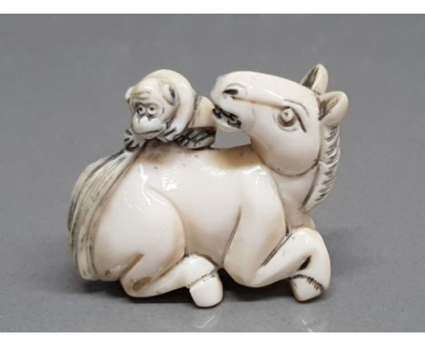 An early 20th century carved netsuke of a horse and monkey