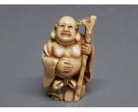 An early 20th century carved ivory netsuke of a buddha