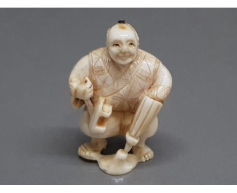 An early 20th century carved netsuke of a cobbler, signed.