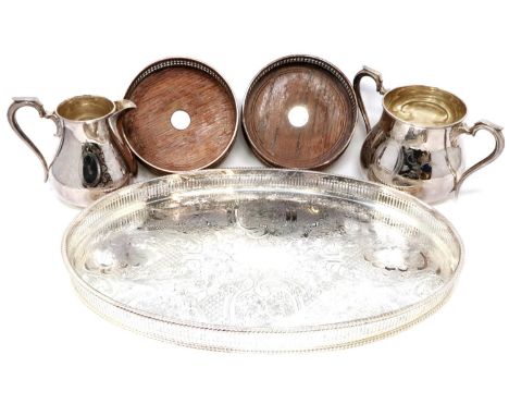 An oval silver plated galleried tray, two plated wine bottle coasters and a Walker &amp; Hall cream and sugar, largest H: 12 