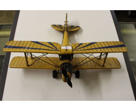 A scratch build tin plate model of a First World War biplane with associated pilot's photograph