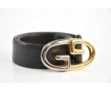 GUCCI; a vintage brown leather GG belt, with gold and silver tone maker's monogram buckle and stamped 'Made in Italy, Gucci S