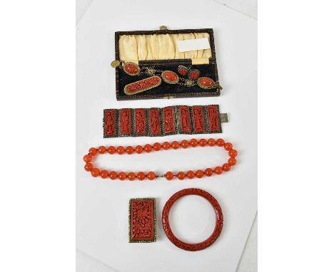 A group of Chinese red lacquered jewellery comprising a panelled bracelet, bangle, two brooches, a bracelet and a pair of scr