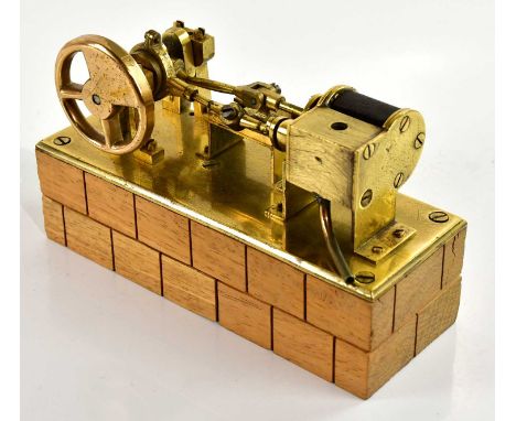 A brass scratch built steam twin piston model engine, on wooden plinth, length 17cm. 