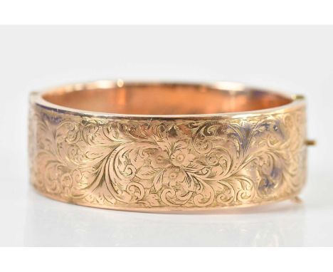 A 9ct rose gold oval hinged snap bangle, with inscription to interior, with engraved detail, internal width 60mm, band width 