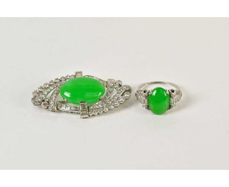 A white metal diamond and jade plaque brooch of lozenge form, with central oval jade cabochon set within a framework of princ