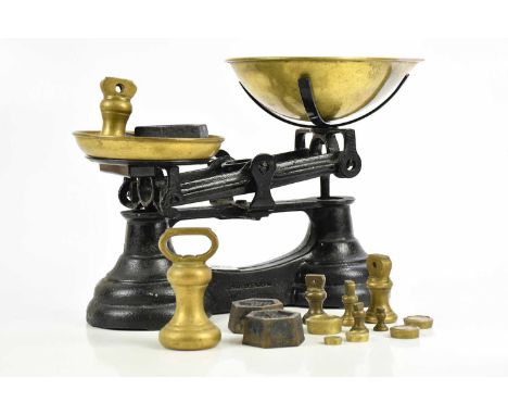 A brass and iron set of scales, stamped 'Made in England', with various weights.