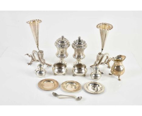 A pair of Chinese white metal bud vases, modelled as five claw dragons supporting the tapering branch with planished decorati