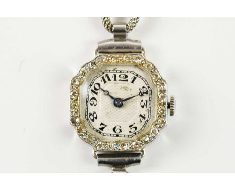 A 9ct white gold diamond set cocktail wristwatch, the engine turned dial set with Arabic numerals, inside a border of diamond