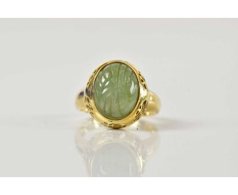 A Chinese 14ct yellow gold and carved jade ring, with pierced detail to the shoulders, size P 1/2, approx 5.7g.