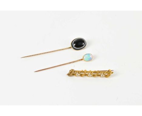 A Victorian 15ct yellow gold seed pearl set bar brooch, approx 3.8g, and two stick pins including an opal set example (3).
