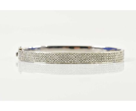 An 18ct white gold and pavé set diamond oval hinged bangle, internal width 64mm, approx 24g.
