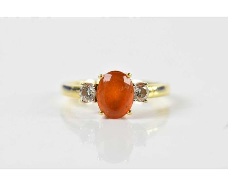 An 18ct yellow gold fire opal and diamond ring, the oval cut opal weighing approx 1.15ct, flanked by twin round brilliant cut