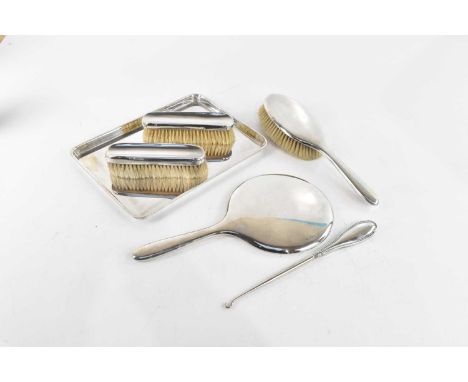 CHARLES S GREEN &amp; CO LTD; a George V hallmarked silver six piece dressing table set comprising three brushes, hand mirror