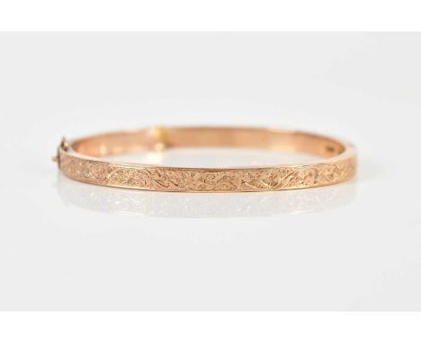 A 9ct yellow gold oval hinged snap bangle with engraved detail, internal width 56mm, approx 6.1g.Condition Report: Several de