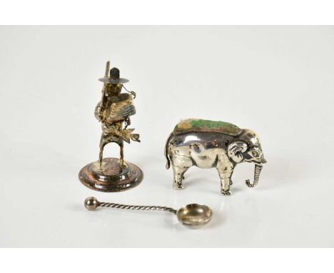 A hallmarked silver pin cushion modelled as an elephant and a Chinese sterling silver figure (2).