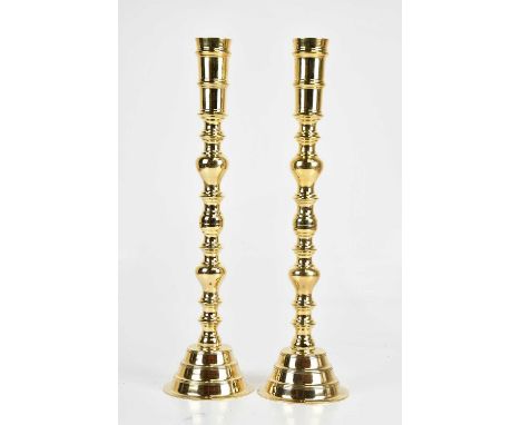A large pair of decorative brass bobbin form candlesticks, height 56cm. (2).