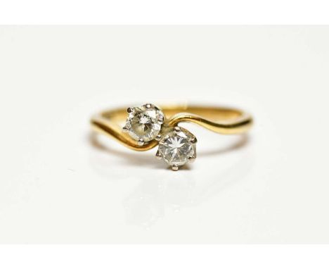 BOODLES; an 18ct yellow gold two stone crossover diamond ring, the round brilliant cut stones totalling 0.41ct, size K 1/2, a