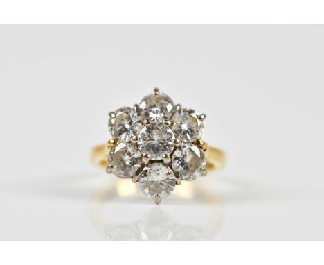 An 18ct yellow gold seven stone diamond floral cluster ring, with stepped design for the round brilliant cut stones totalling
