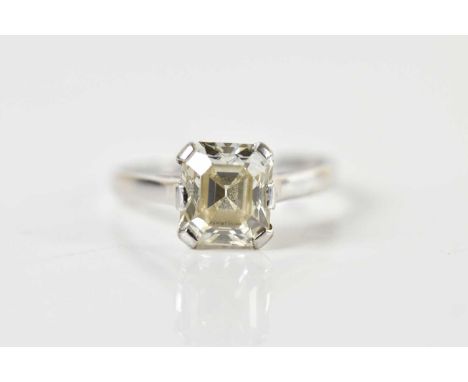 A white metal diamond solitaire ring with the emerald cut claw set stone weighing 2.11 cts, graded clarity VS, colour K/L, si
