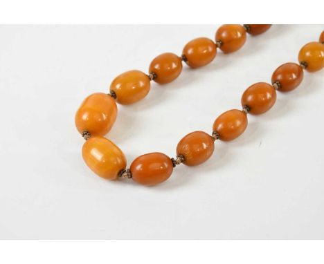A vintage hand tied graduated egg yolk/butterscotch amber necklace, length approx 58cm, largest bead 30 x 20mm, smallest bead