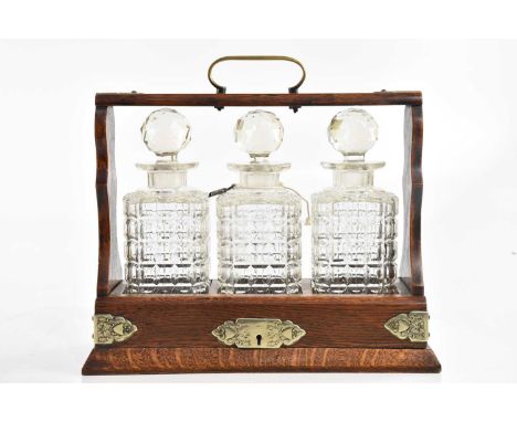An early 20th century oak cased three section tantalus, height 33cm.