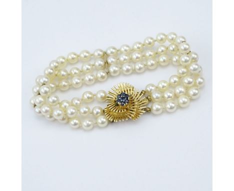 Vintage Three Strand Pearl Bracelet with 14 Karat Yellow Gold and Sapphire Clasp. Pearls measure 5.5mm. Signed 14K. Good vint