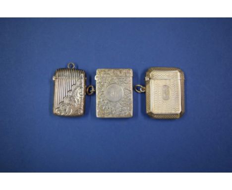 A silver vesta case having chased floral decoration; together with two engine turned silver vesta cases.