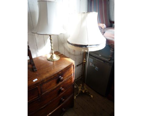 A early to mid 20th Century brass standard lamp, raised on three splayed feet, together with a brass table lamp, both with sh