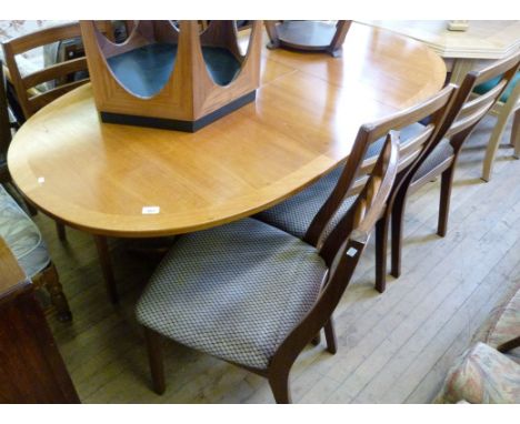 A post war Nathan teak dining suite comprising twin pillar extending dining table with one extra leaf and six ladder back cha