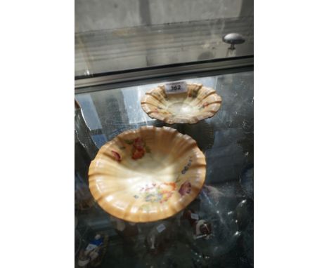 A pair of Royal Worcester blush ivory circular pin dishes raised on shell feet.