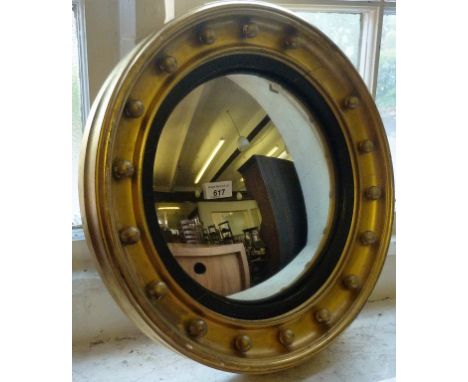 A mahogany hanging shelf together with a circular gilt convex mirror.