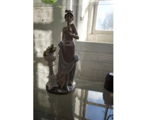 A large size Lladro figurine depicting a lady beside a jardiniere of flowers. CONDITION REPORT: Flower in hand broken off and