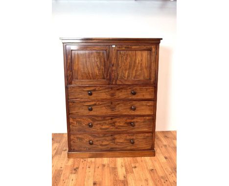 A 19th Century Victorian mahogany press, the flared top over a double door cabinet, atop a bank of four drawers raised on a p