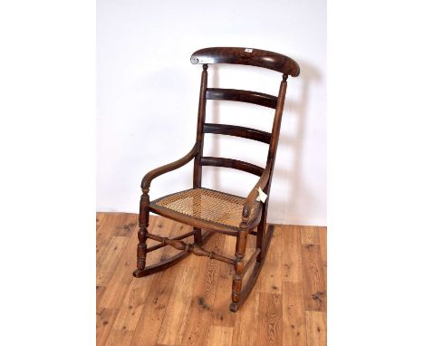 A 20th Century scumble-painted rocking chair, the shaped crest rail, over a ladder backrest over a rattan seat, raised on cur