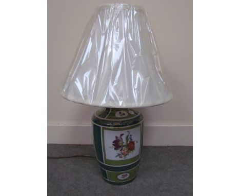 A ceramic lamp base, teal and green ground with gilt edged floral spray panels with a cream shade