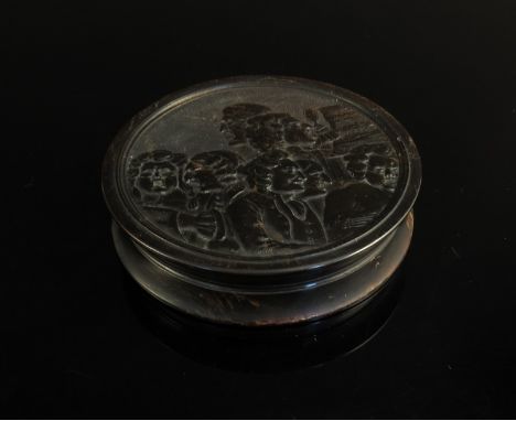 A 19th Century pressed horn circular snuff box with images of gentlemen with song sheets to lid and deer under oak tree to ba