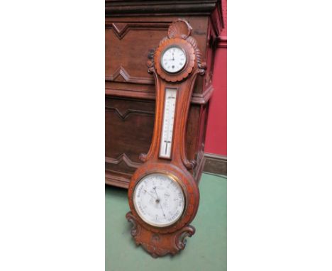 A late 19th early 20th Century Admiral Fitzroy's Aneroid barometer with carved oak case set with clock to top, 93cm tall 