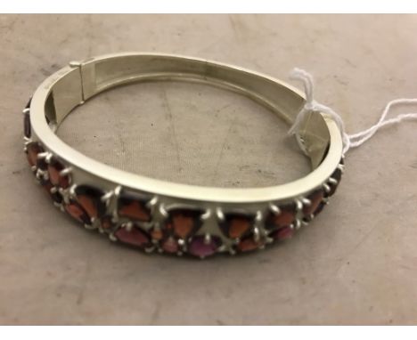 A silver abstract bangle set with garnets