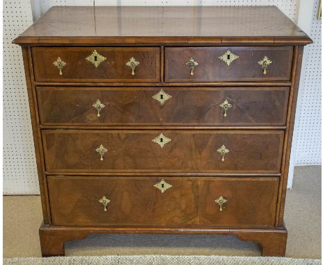 CHEST, early 18th century Queen Anne walnut and feather banded with two short above three long drawers on bracket feet, 101cm