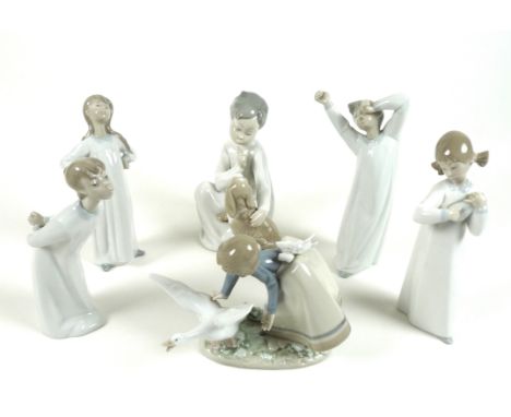 A group of six Lladro figures, comprising Wild Goose Chase, number 5553, 15cm high, Nino con Perro, number 4522, 19.5cm high,