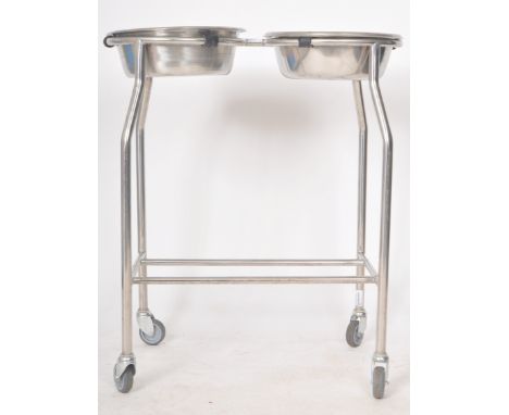 A contemporary medical / industrial twin basin washstand of polished steel construction with each bowl removing form the tubu