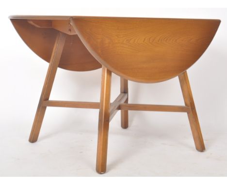 Ercol - A retro 20th Century elm and beechwood oval top drop leaf dining table raised on splayed square cut and moulded suppo