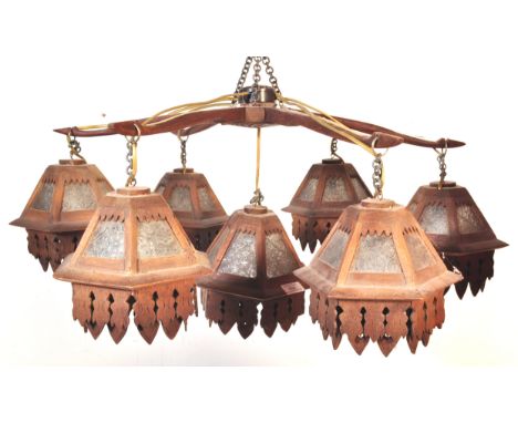 An early 20th Century Arts &amp; Crafts six branch chandelier of oak construction. Each arm having carved hexagonal shade wit