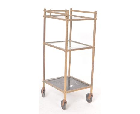 A retro vintage 20th Century Hollywood regency style brass framed three tier trolley of square form with top rail having fini