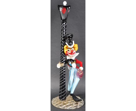 A large retro 20th Century Murano studio art glass sculpture in the from of a stylized clown leaning on a black and white twi