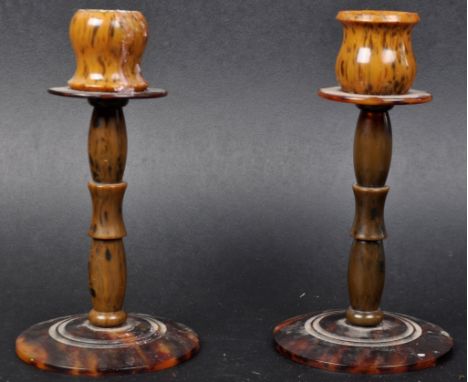 A matching pair of vintage 20th Century Art Deco bakelite tortoiseshell candlesticks having drip tray tops on slender stems u